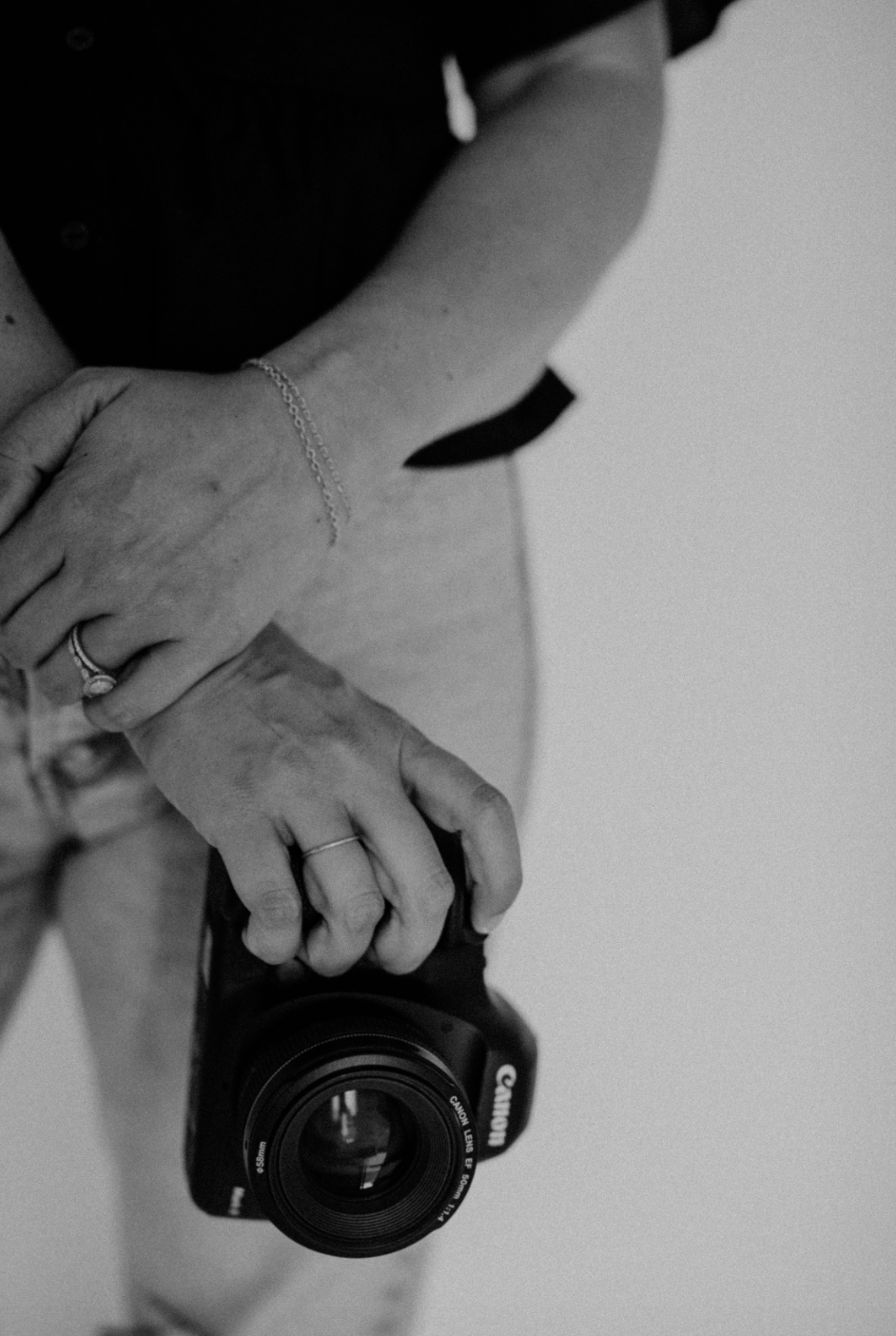 Black and white close-up of Michelle's hands holding her Canon camera
